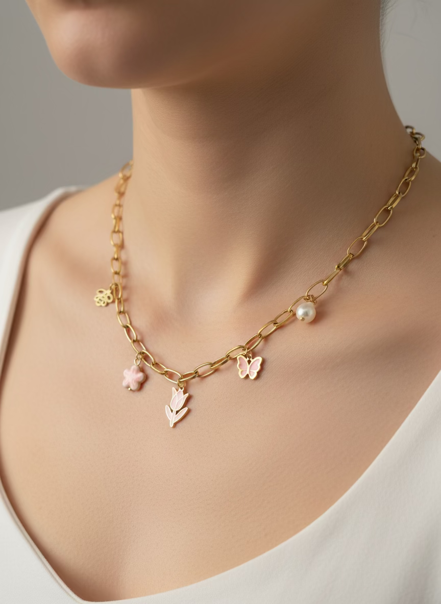 Gold chain necklace with floral charms on a black background